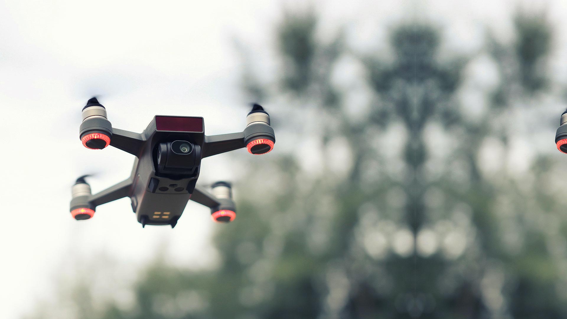 A camera-equipped multirotor drone in flight