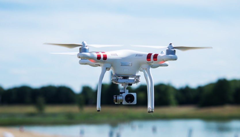 A camera-equipped multirotor drone in flight